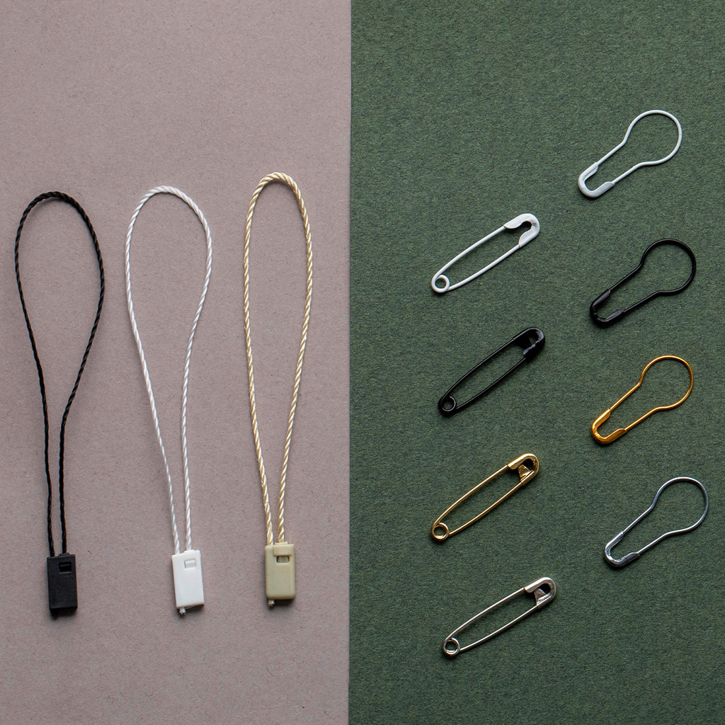 Attaches et cordons pour étiquettes suspendues avec épingles de différentes couleurs.