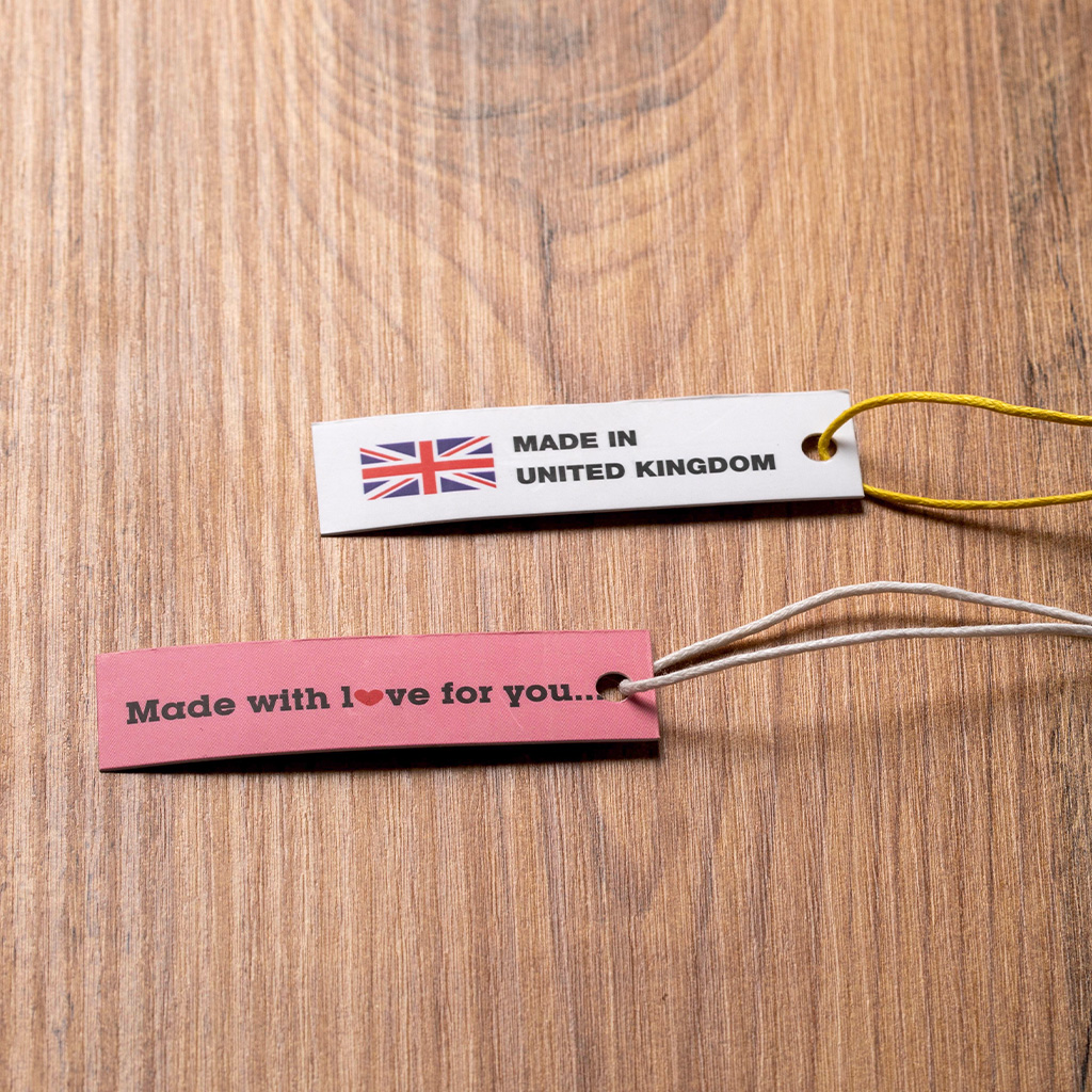 Étiquettes en tissu avec drapeau britannique et cordon sur table en bois.
