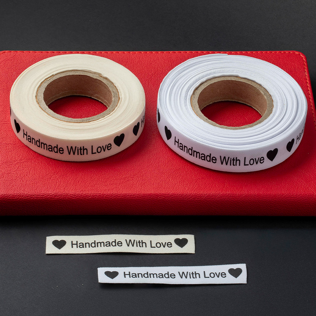 Rouleaux d'étiquettes en coton ou satin imprimées avec la mention Handmade with Love.