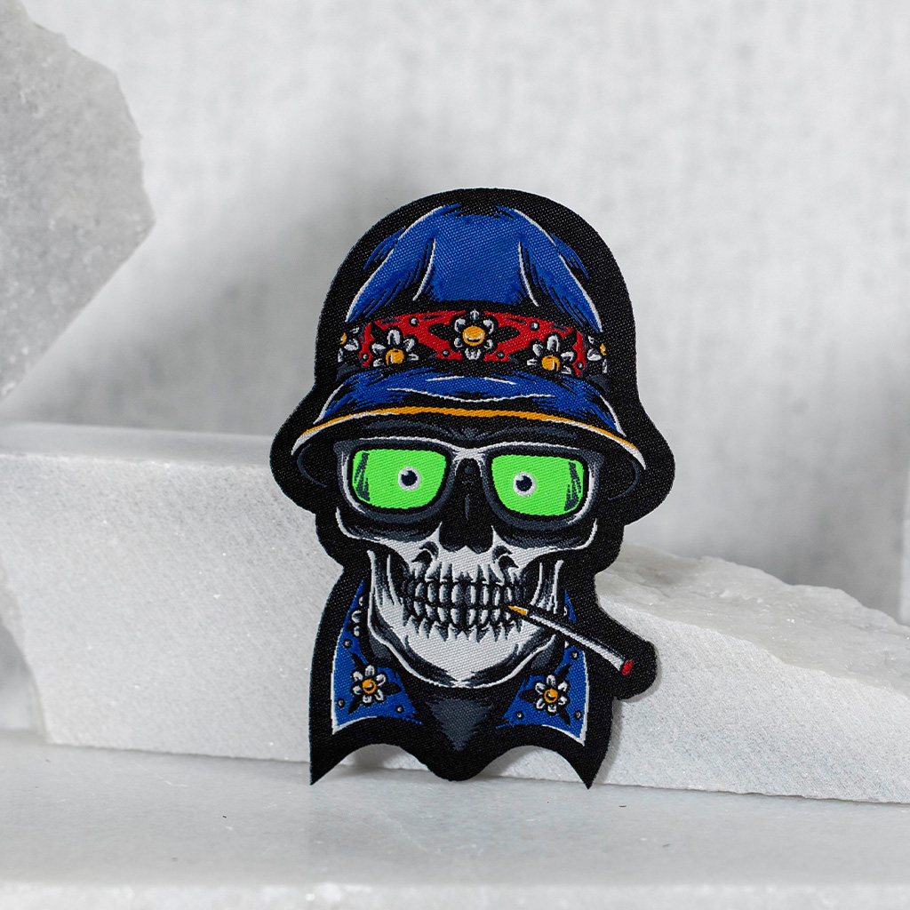 Patch brodé crâne stylisé avec chapeau bleu.