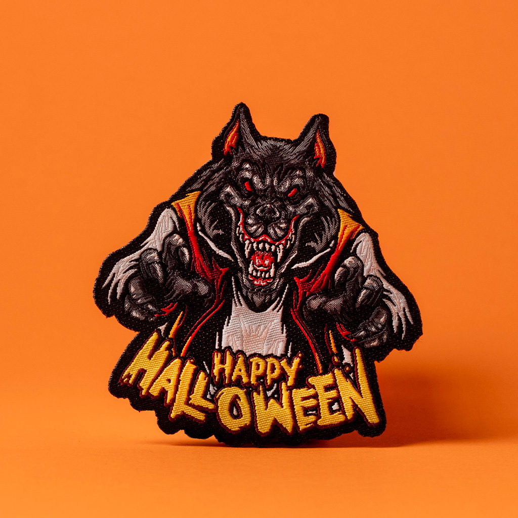 Patch brodé loup de l'enfer avec écriture Happy Halloween sur fond orange.