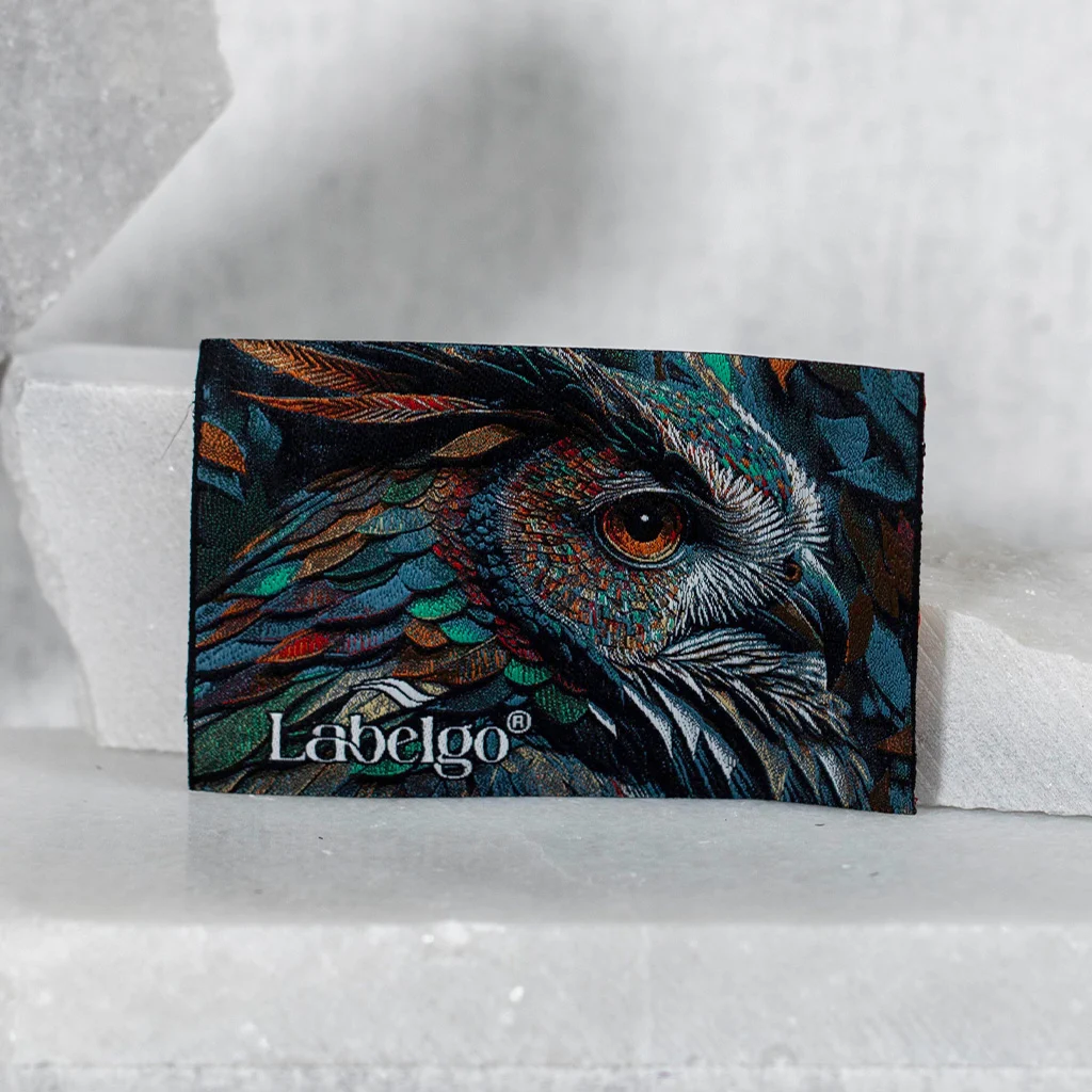 Étiquettes textiles imprimées satin sur fond rouge confectionné par LabelGo