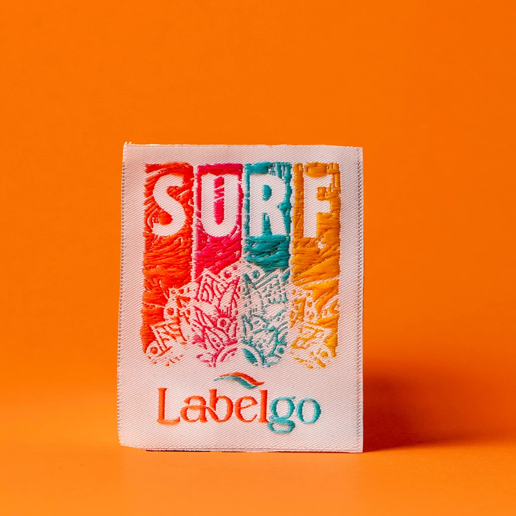 Étiquette tissée rétro SURF sur fond orange confectionné par LabelGo